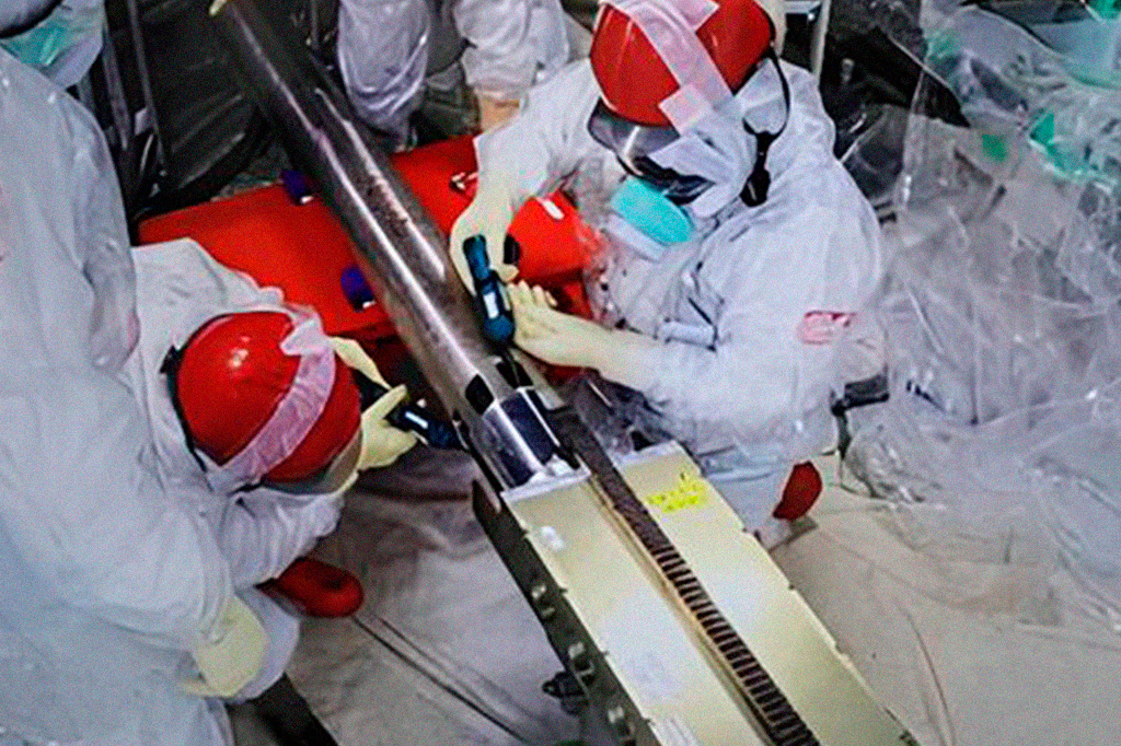 0411-Nuclear-De-Fukushima-Daiichi-Layout_Site(2) Funcionário da usina Fukushima recolhendo tubo.