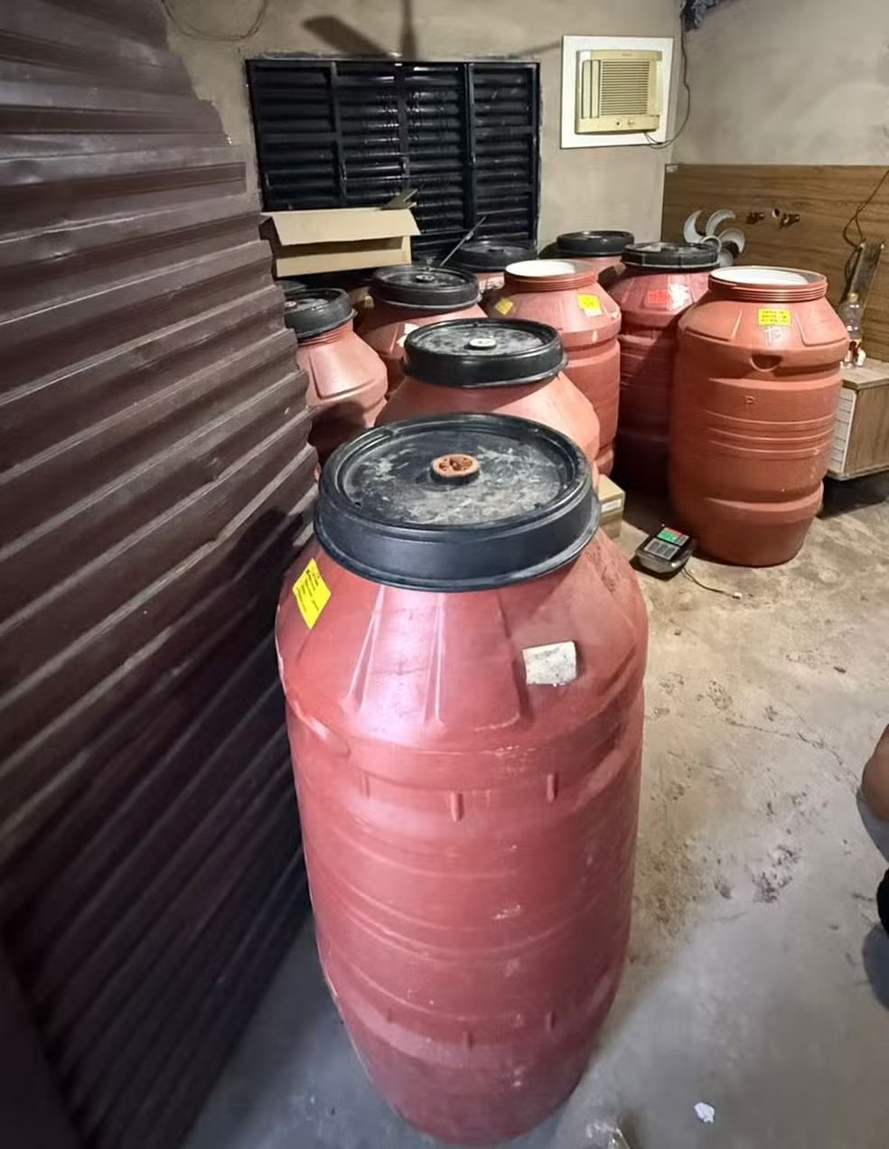 Drogas estavam escondidas em barris em uma chácara usada como depósito e “tribunal do crime”; uma mulher está foragida