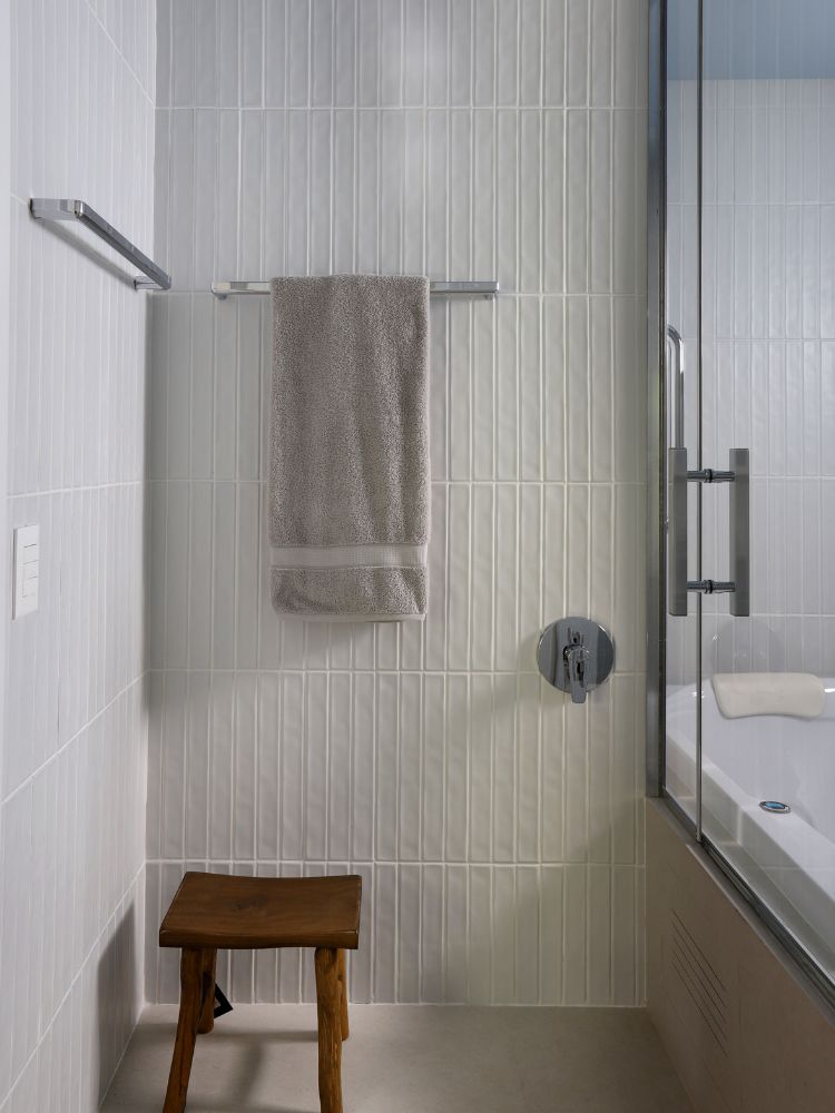 Apartamento-Decorado-158-M2-12 Banheiro com banquinho de madeira e toalheiro ao lado de box com banheira