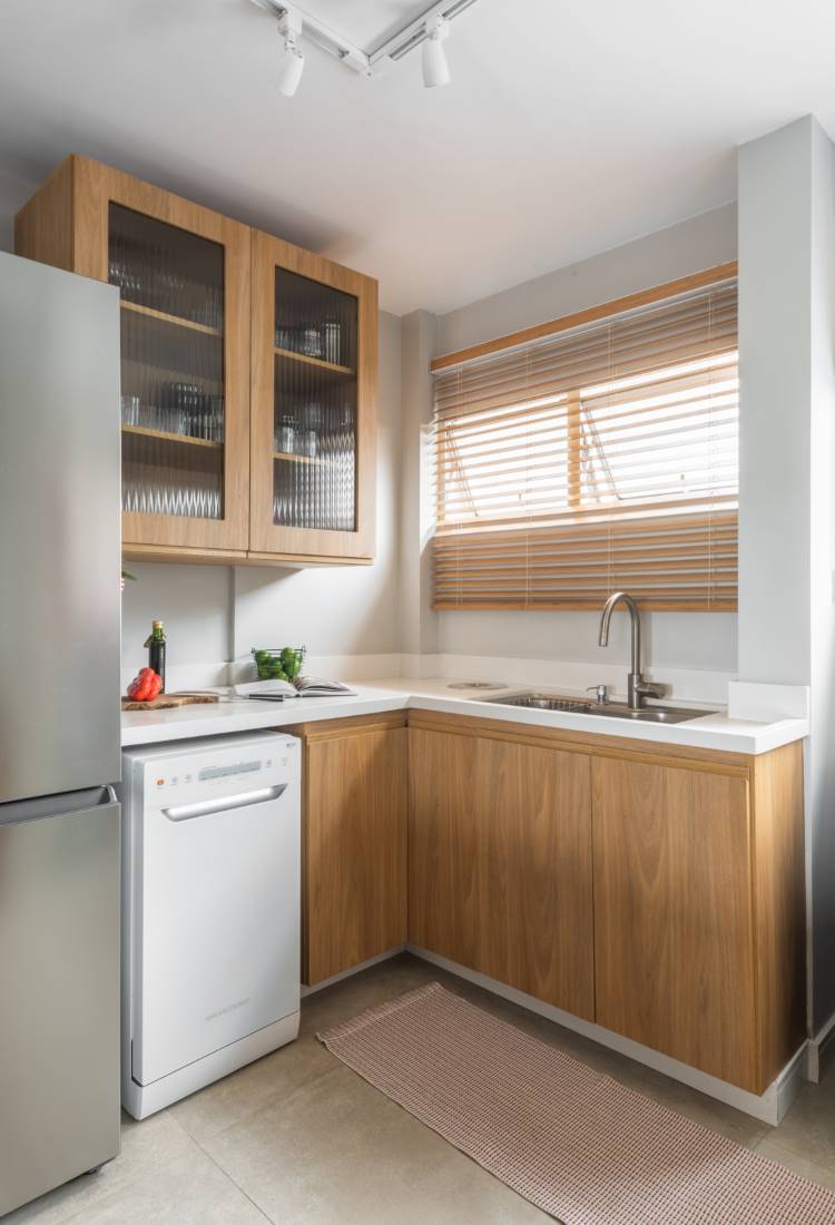 Cozinha-Rustica-Moderna-3 Desculpe, a imagem fornecida não se alinha com o termo "cozinha rústica moderna". Ela descreve uma cozinha com estilo contemporâneo. A descrição mais adequada seria: Cozinha compacta com armários de madeira clara e bancada branca. A imagem mostra um refrigerador de aço inoxidável, lava-louças branca e uma janela com persiana de madeira.