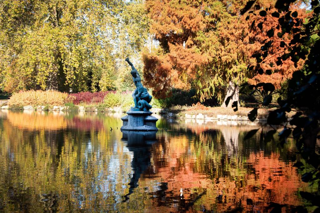 A Statue In A Lake Surrounded By Trees In Autumn Kew Gardens Londres