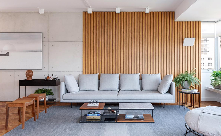 parede revestida com painel ripado atrás do sofá na decoração de sala de estar.