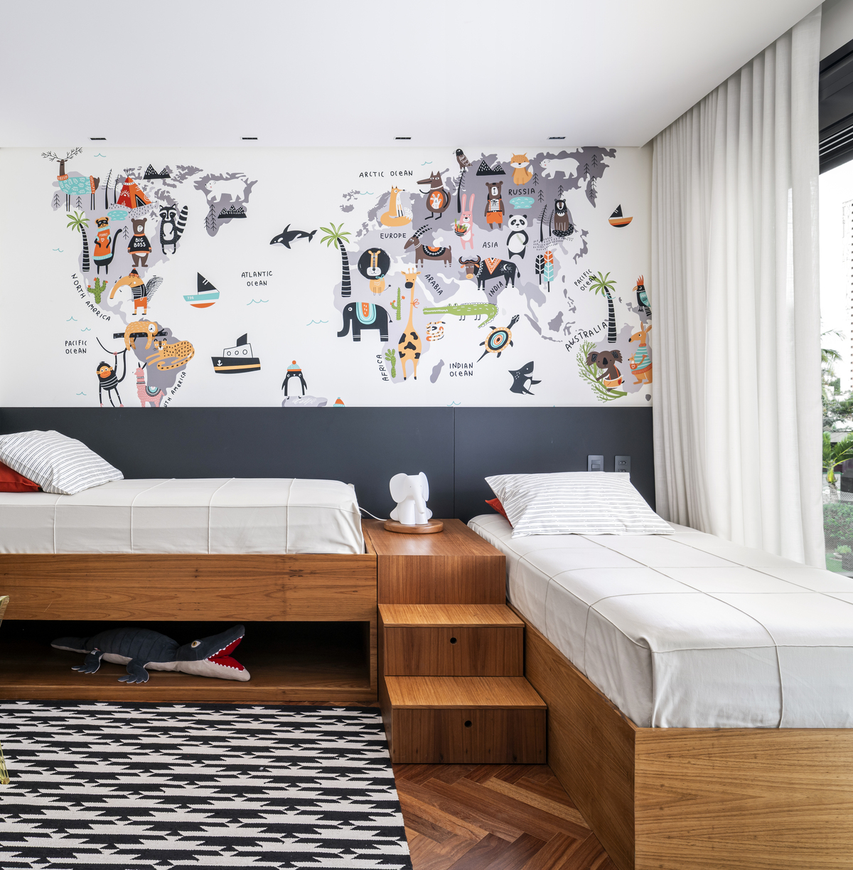 Quarto infantil criativo com móveis de madeira, tapete e tecidos naturais aconchegantes.
