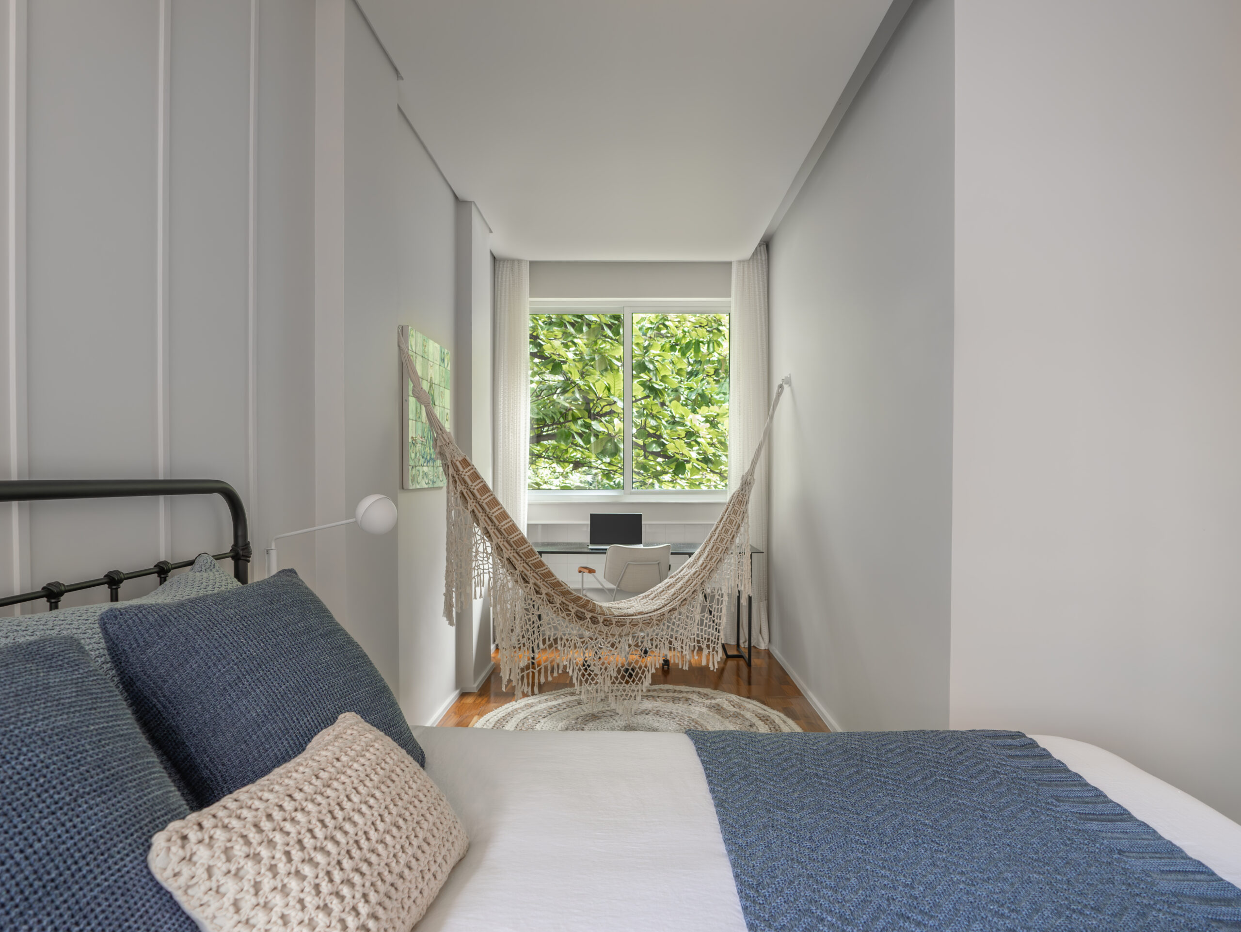 Apartamento-Leblon-Gabriella-Machado-02 Suíte master com cortina em renda e cantinho de home office com mesa e rede.