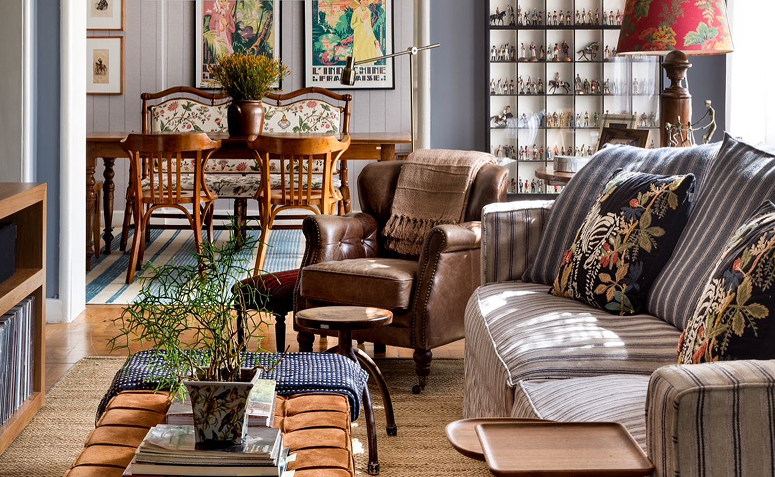 sala maximalista com mistura de cores, texturas e objetos afetivos.