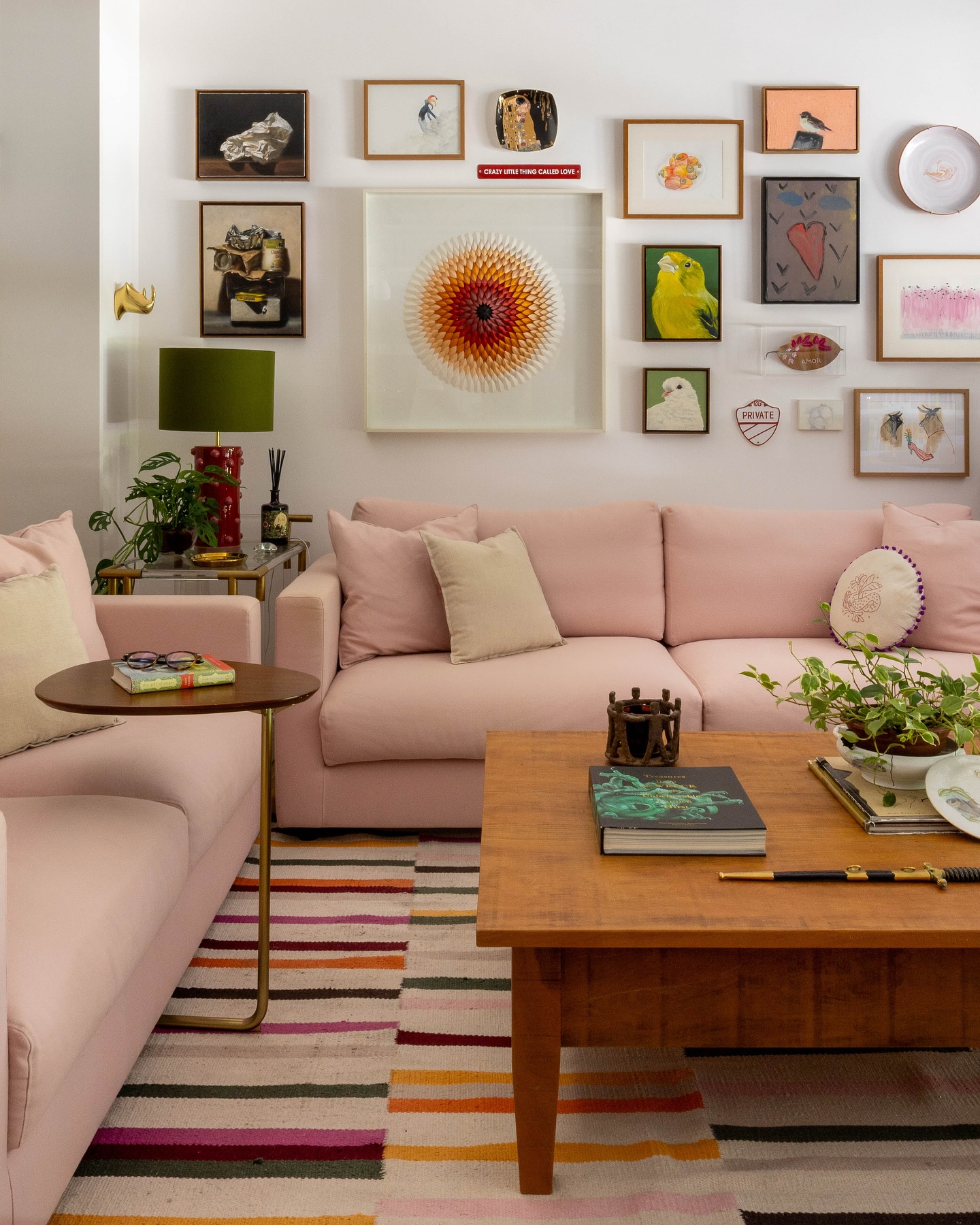 sala com móveis coloridos, quadros de diferentes tamanhos e decoração maximalista.