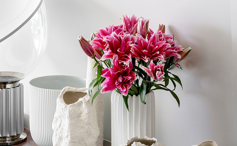 arranjos com lírios, flor associada à pureza, renovação e espiritualidade.