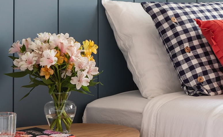 vaso com astromélias ao lado da cama, simbolizando amizade verdadeira, cumplicidade e gratidão.