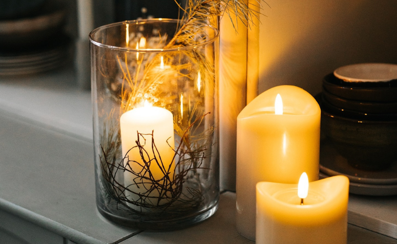 Velas acesas ao lado de ramo natural em uma decoração de Natal escandinava com iluminação suave e aconchegante