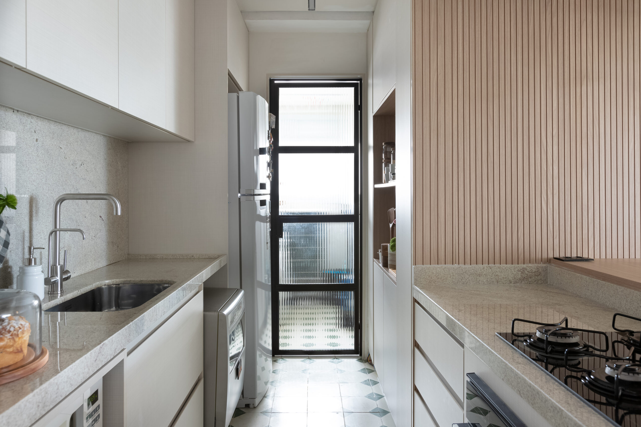 cozinha integrada com porta de vidro separando da lavanderia.