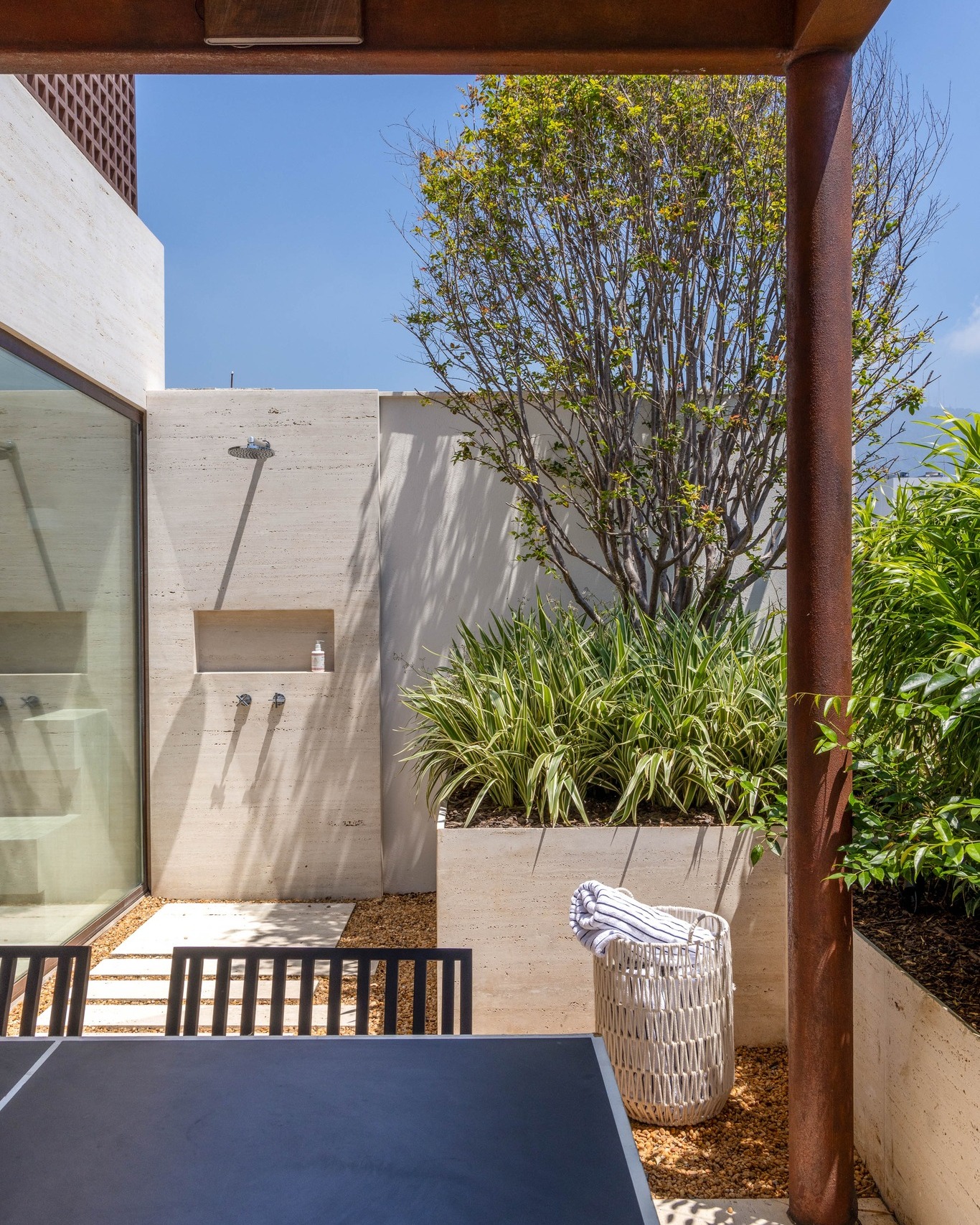 ducha externa no quintal com revestimento em mármore travertino.