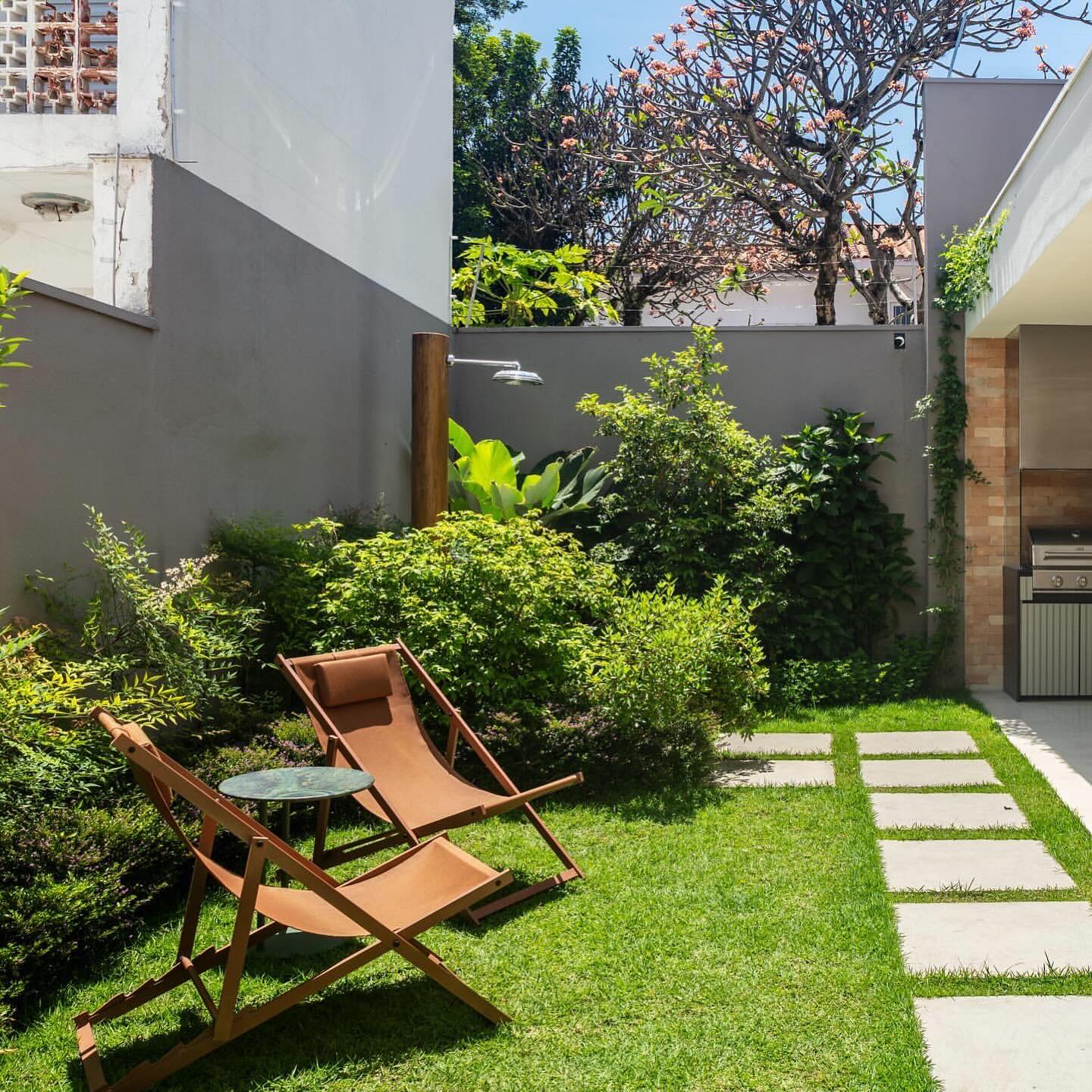 chuveiro no jardim de madeira cercado de plantas tropicais.