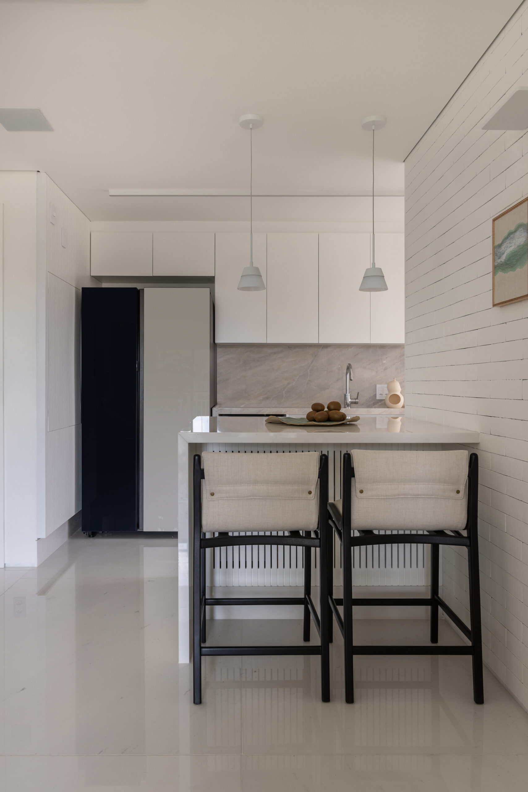 área social integrada com decoração branca e preto em detalhes.