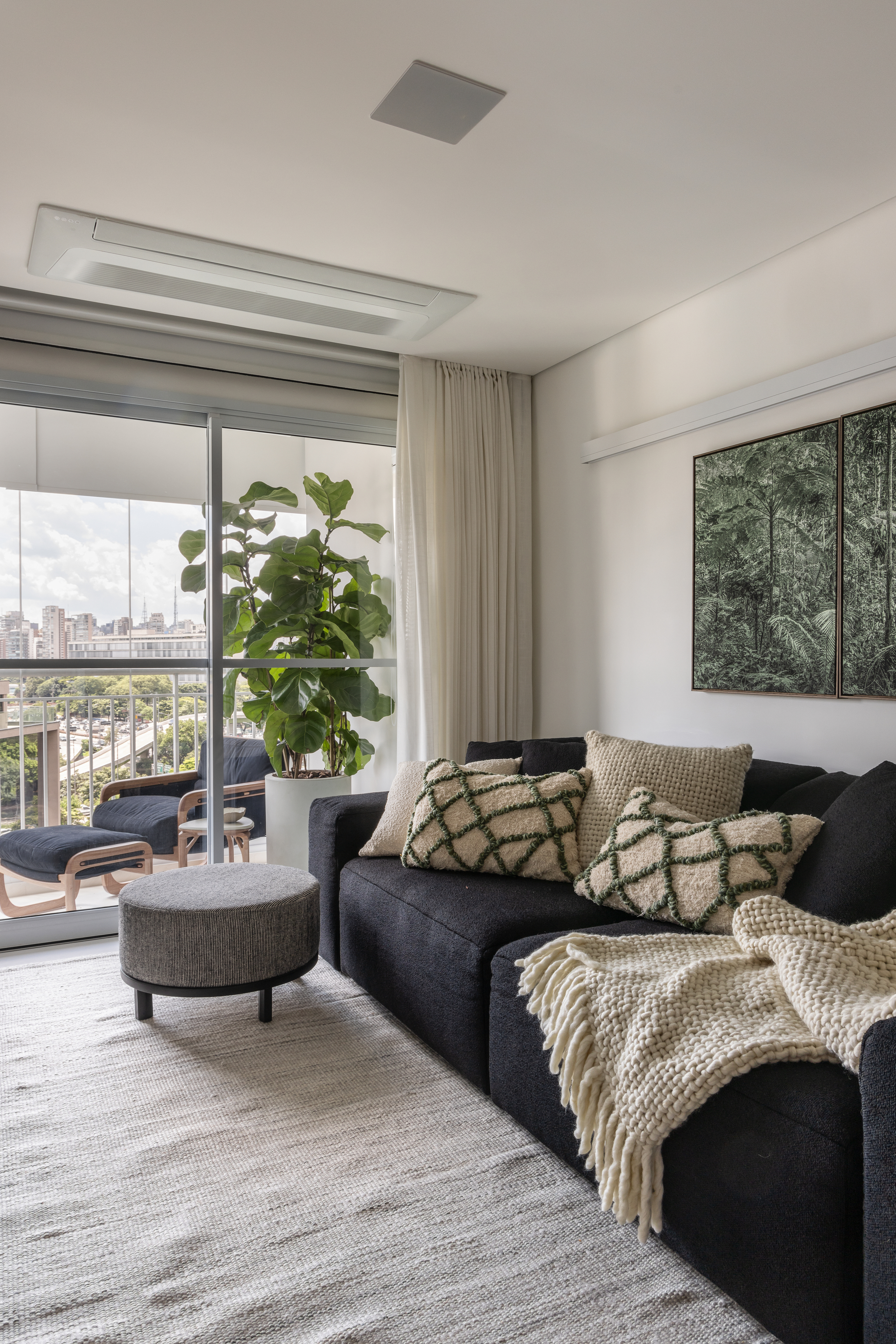 sala de estar branca com sofá preto e detalhes em contraste elegante