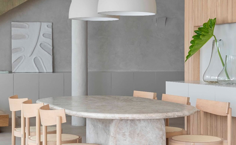 sala de jantar com parede em cinza-claro, representando o uso de cores que acalmam em um ambiente moderno, neutro e visualmente tranquilo