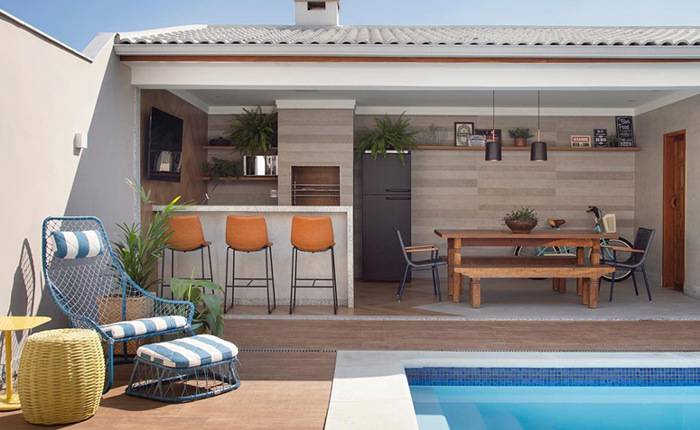 Quintal com diferentes áreas de convivência, incluindo mesa, churrasqueira e espaço para refeições ao ar livre.