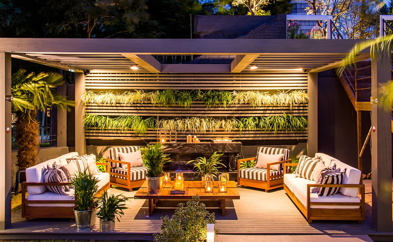 Quintal iluminado com luzes suaves e lanternas, criando um clima aconchegante.