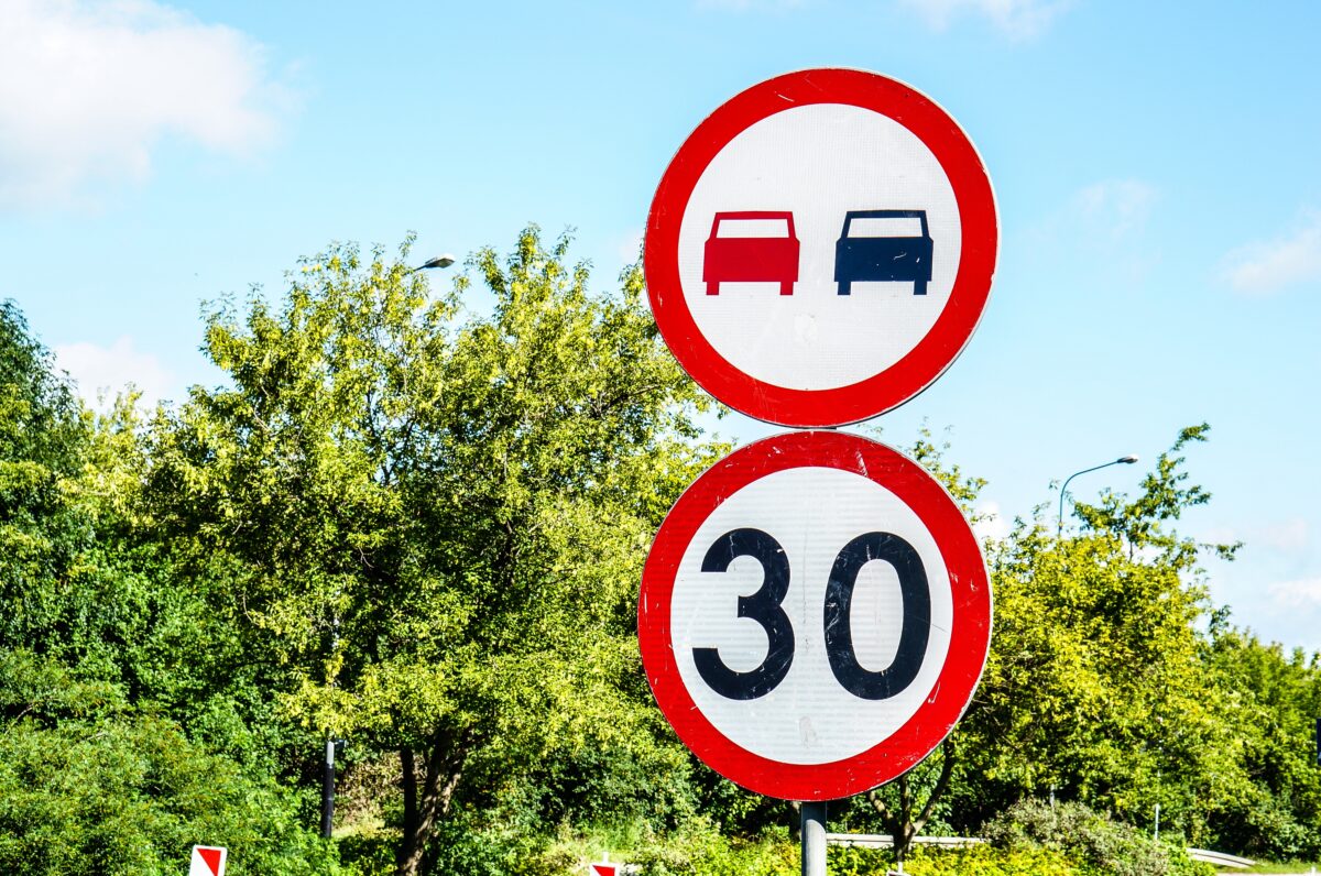 Sign-Indicating-Speed-Limit-Thirty-No-Overtaking-Against-Green-Trees 2025 word3