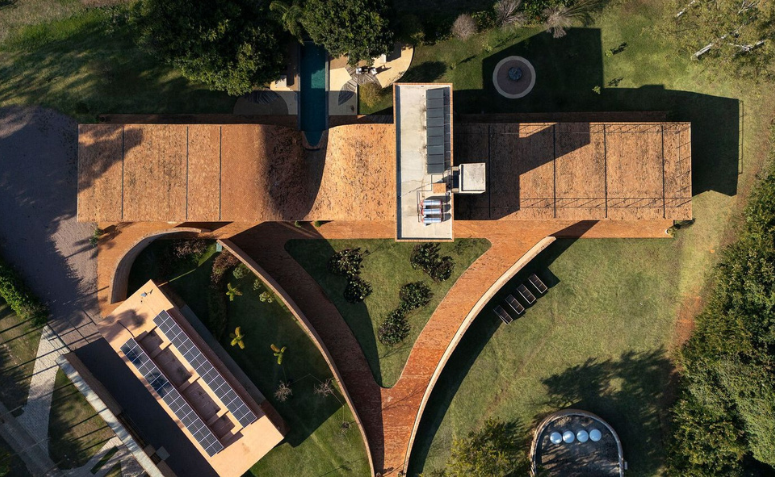 Vista aérea da Passive House destacando o jardim triangular no centro do projeto.