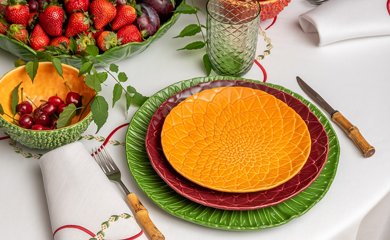 Mesa posta com toalha clara, pratos, talheres e copos organizados de forma harmoniosa