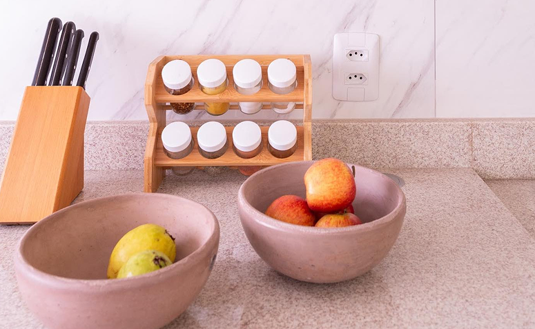 temperos dispostos sobre a bancada de cozinha em suporte para condimentos.