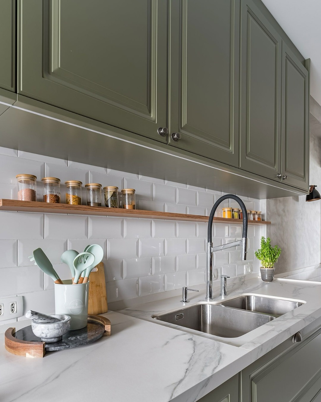 Prateleira sobre a pia de cozinha com potes de temperos organizados em fileira, trazendo praticidade e um toque decorativo ao ambiente.