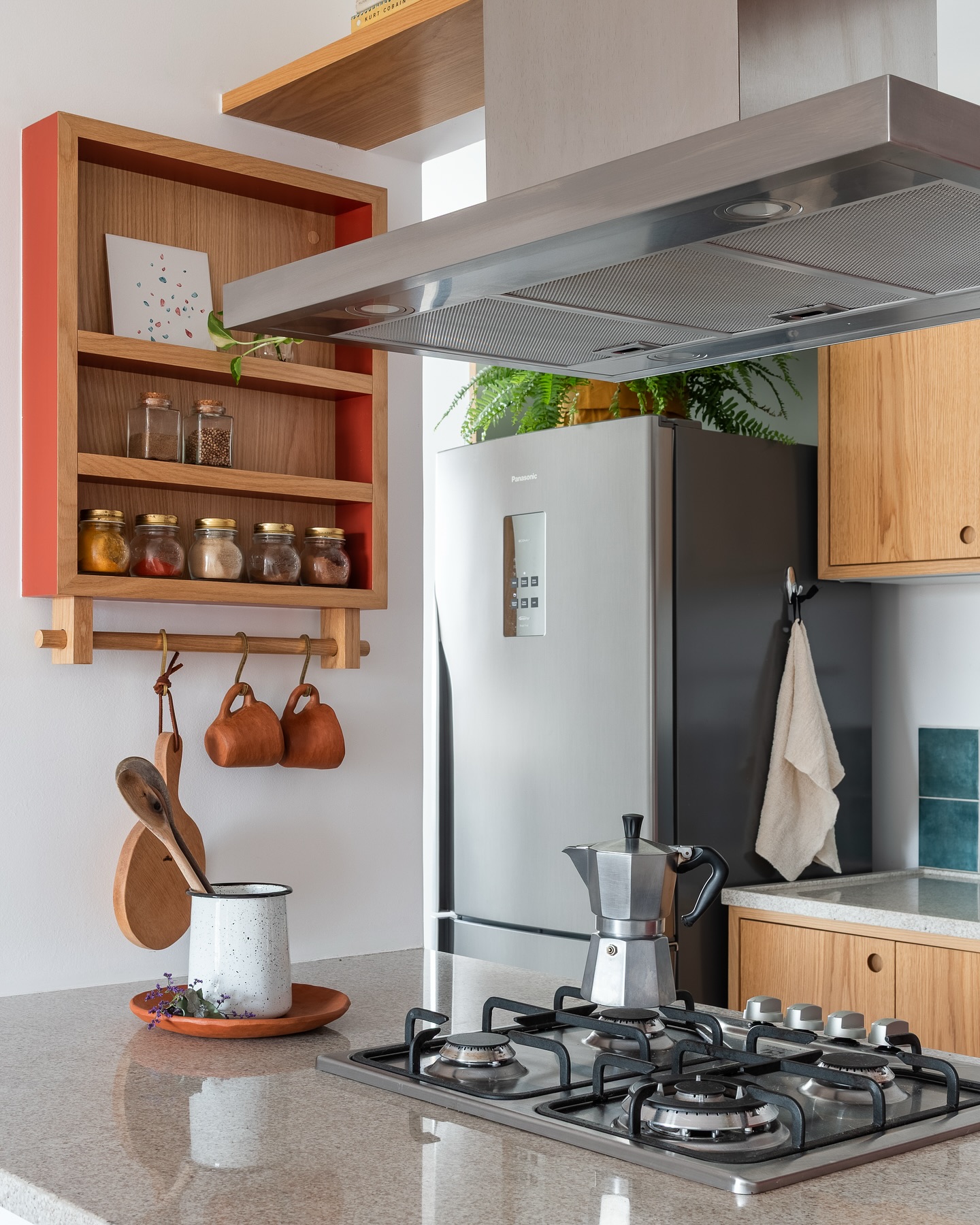 Nicho de cozinha ao lado do fogão com potes de temperos organizados, garantindo praticidade no preparo das receitas e um toque de charme ao ambiente.