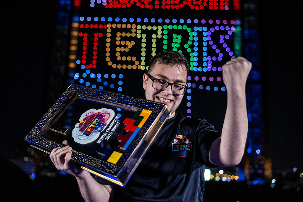 1512-Tetris-Layout_Site Fotografia de divulgação da parceria da Red Bull com o jogo Tetris. Imagem de um homem segurando o trofeu do tetris.