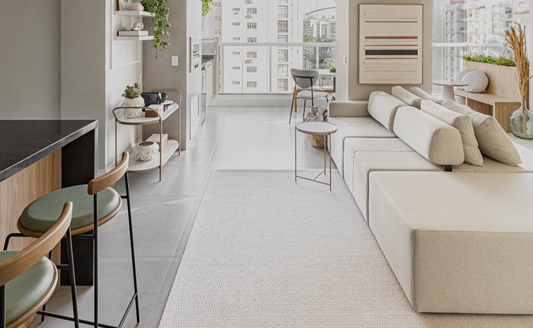 Sala clara e organizada com decoração minimalista em tons neutros, transmitindo leveza e sensação de limpeza.