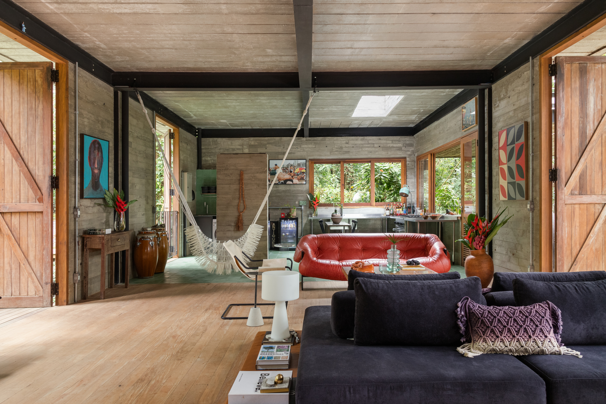 Ambientes integrados, unindo sala, cozinha e varanda com vista aberta para a mata.