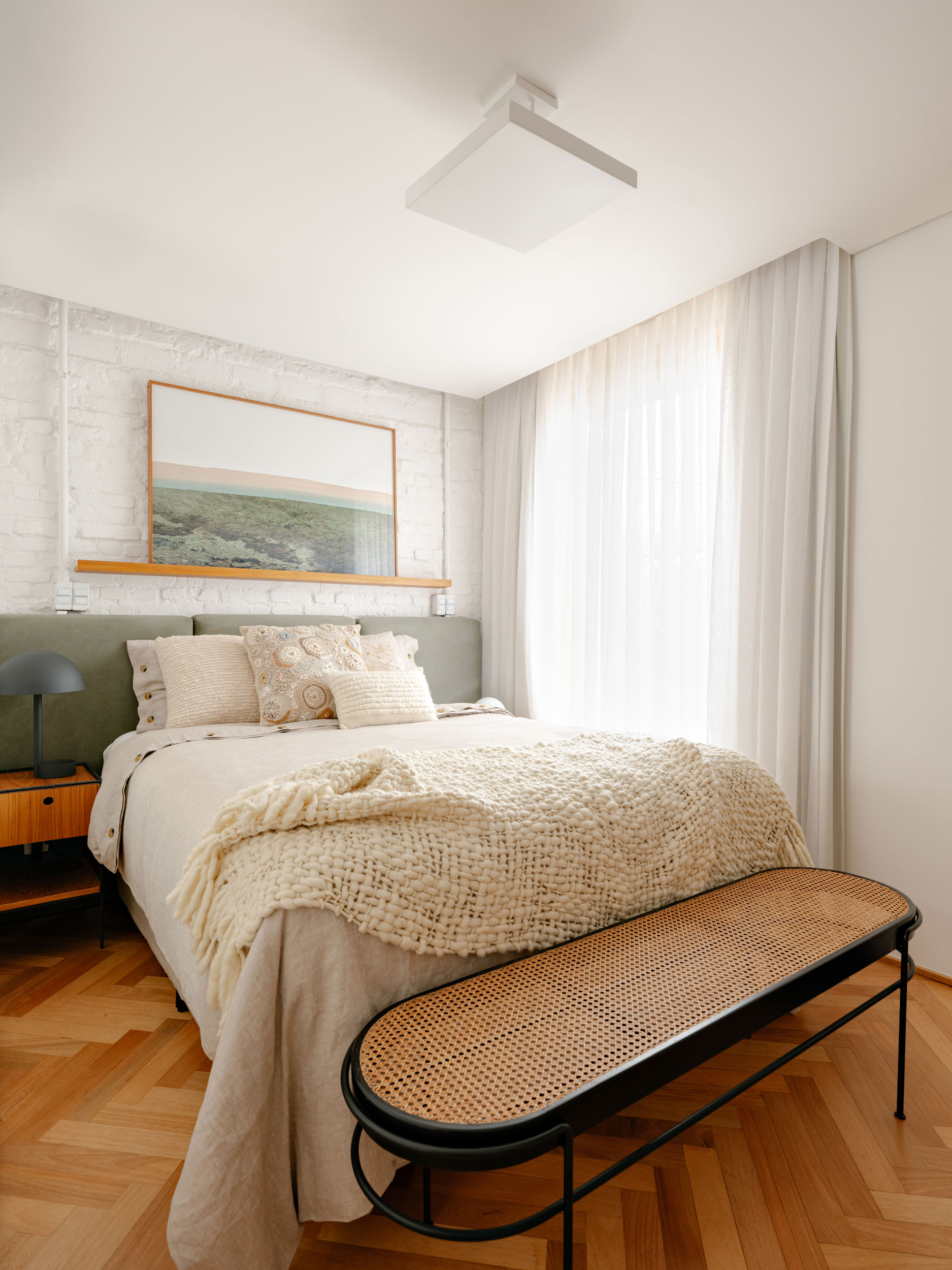 Suíte master da Casa MA com janela ampla de madeira freijó e banheiro com ladrilho hidráulico rosa e cimento queimado.