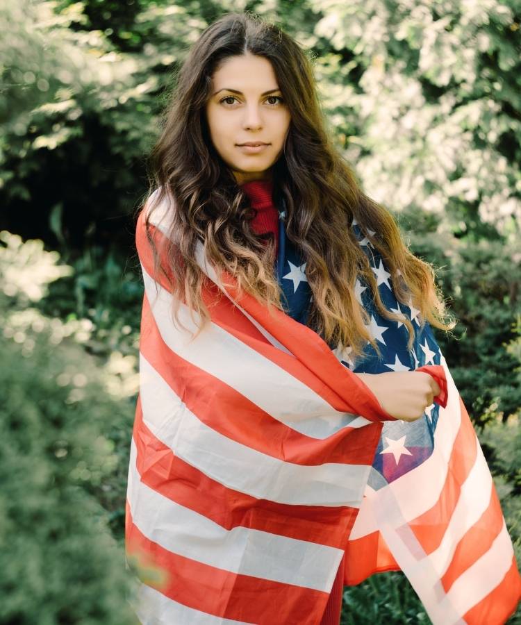 2-American-Dream-Sonho-Brasileiro Foto de mulher morena enrolada em bandeira dos Estados Unidos