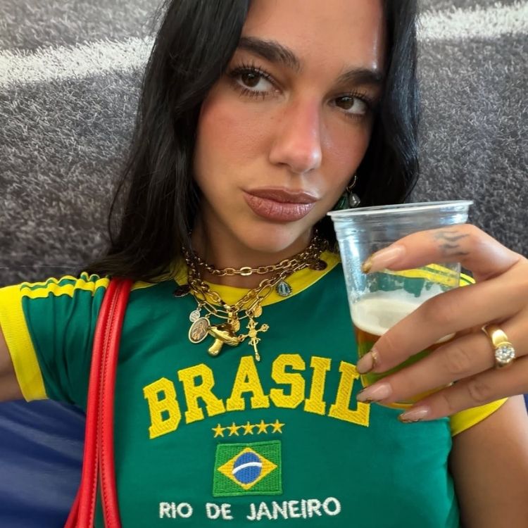 4-American-Dream-Sonho-Brasileiro Foto de Dua Lipa vivendo o sonho brasileiro com blusa verde e amarela e copo de cerveja