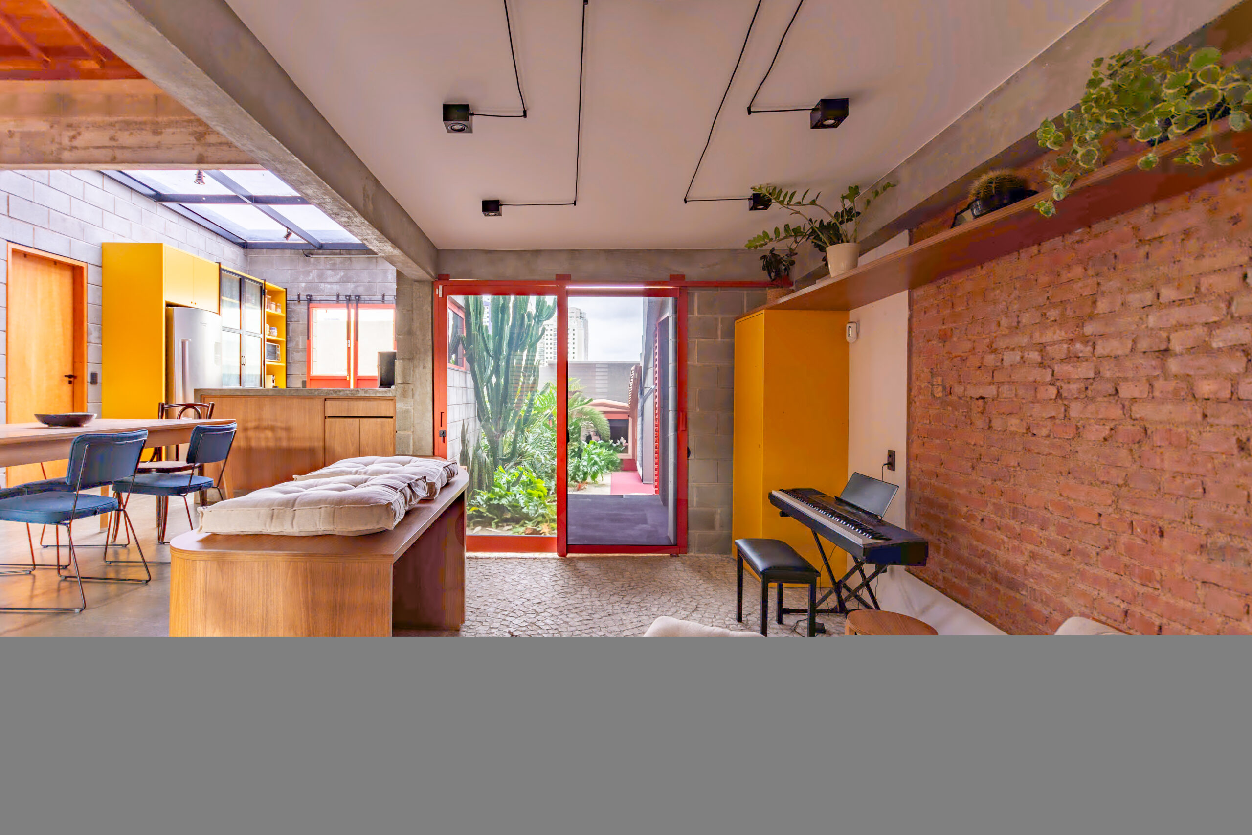 Detalhe da estrutura original da antiga creche com tijolos aparentes preservados na reforma residencial