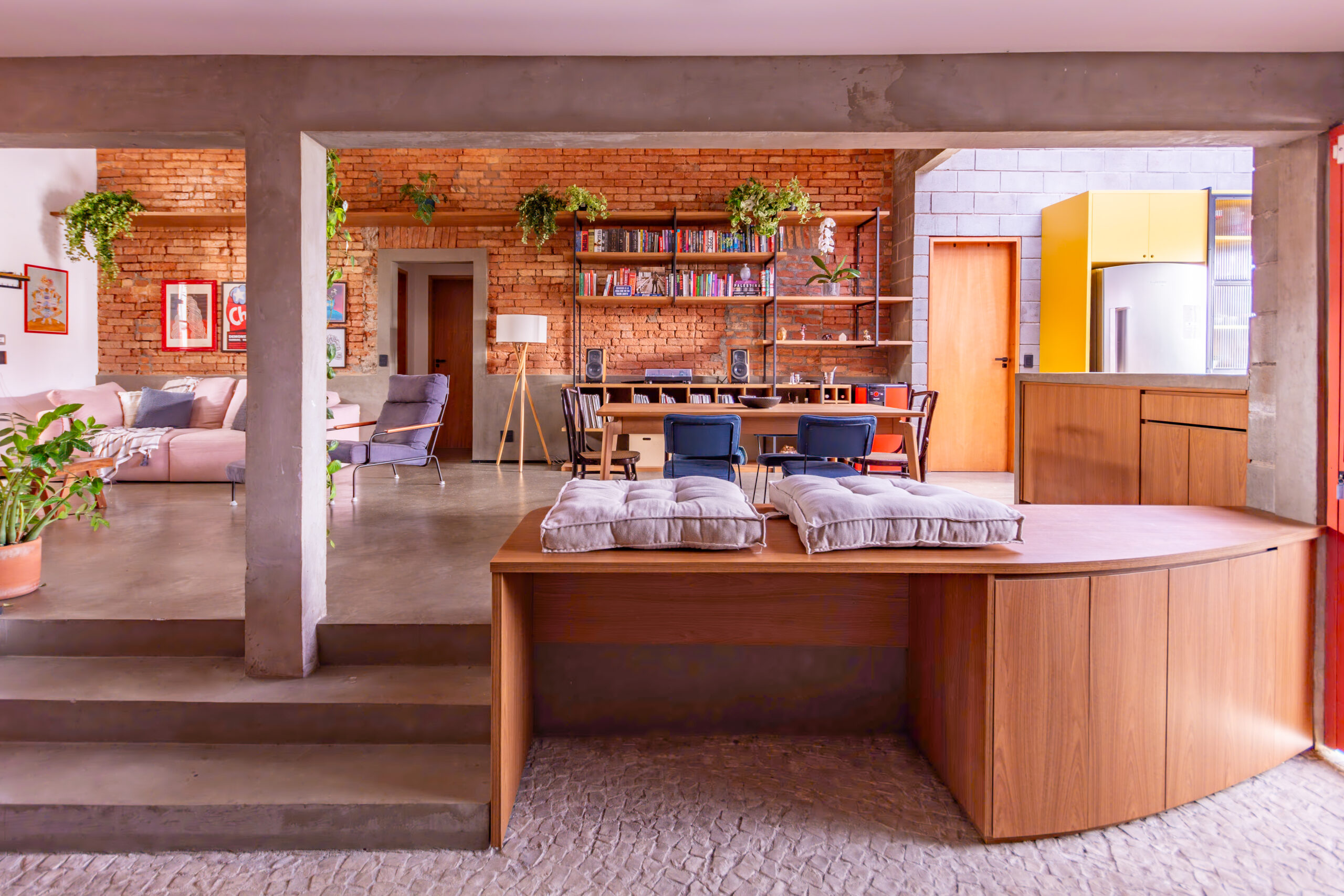 Interiores da casa reformada com móveis, livros e objetos pessoais integrados ao projeto