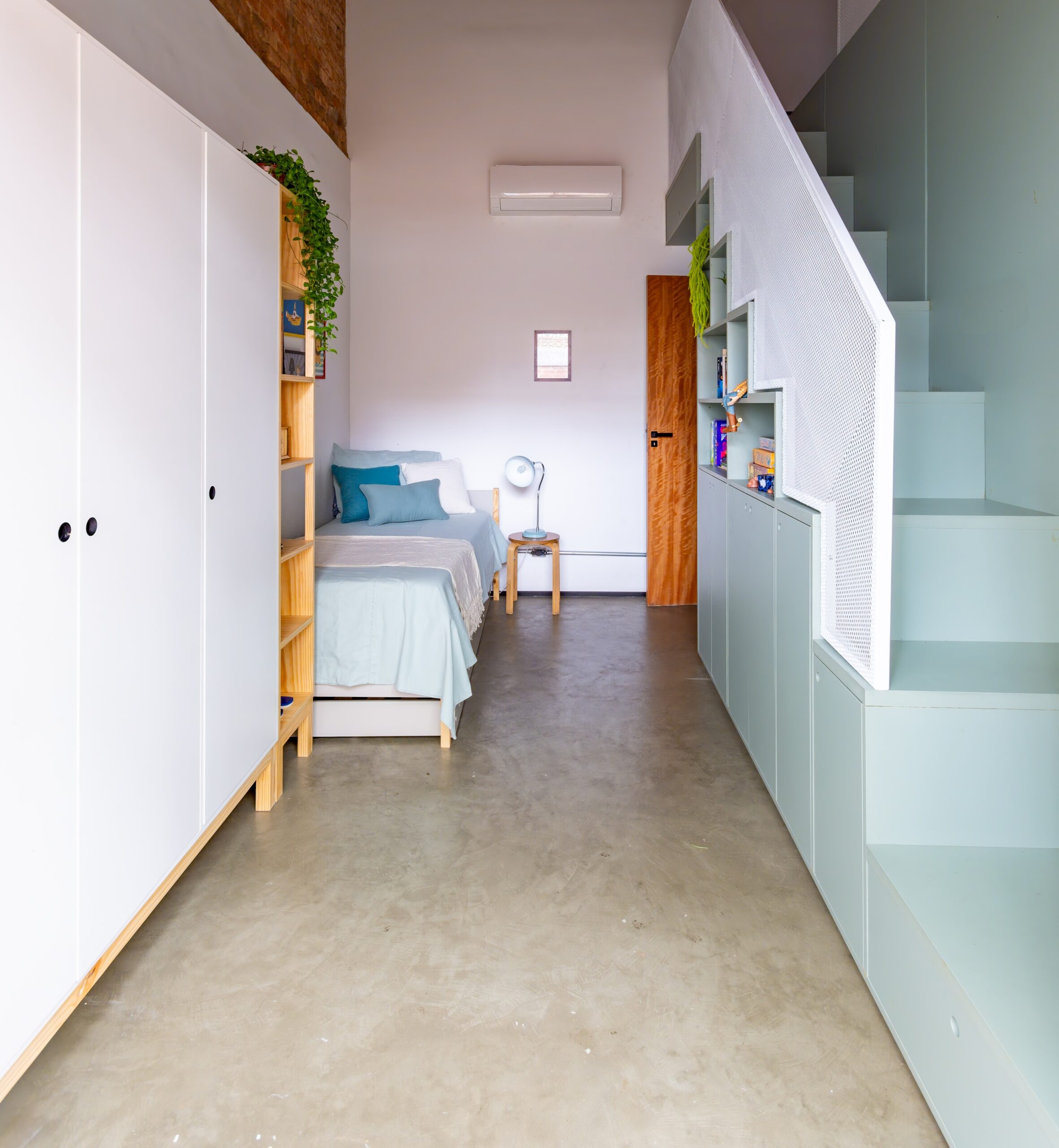 Marcenaria sob medida embaixo da escada com estante integrada ao projeto arquitetônico