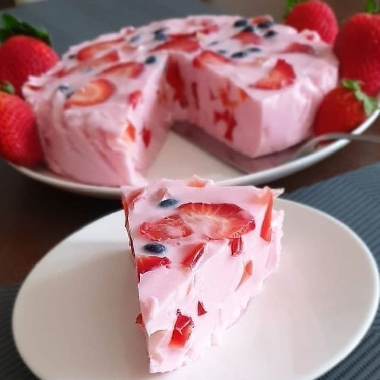 Foto-Quadrada-Fashion-Bubbles-6 Fatia de doce vermelho encorpado com morango e mirtilo e o resto do bolo em um refratário ao fundo