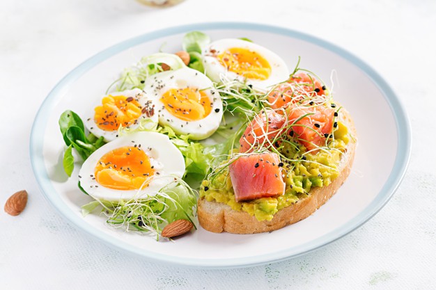 Breakfast-Healthy-Open-Sandwich-Toast-With-Avocado-Salmon-Boiled-Eggs-Herbs-Chia-Seeds-White-Plate-With-Copy-Space-Healthy-Protein-Food_2829-20256 Prato branco com os cozidos, verduras e avocado toast com salmão