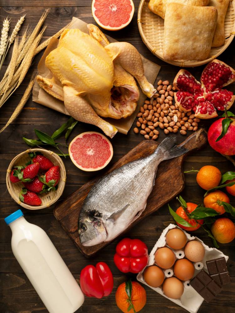 Alimentos-Dengue Mesa com alimentos como peixe, frango, morango, laranja, tomate, leite e ovos