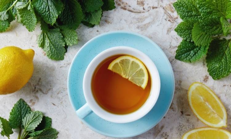 Chá De Erva-Cidreira Com Limão. Chás de erva-cidreira com meia rodela de limão em xícara com pires azul