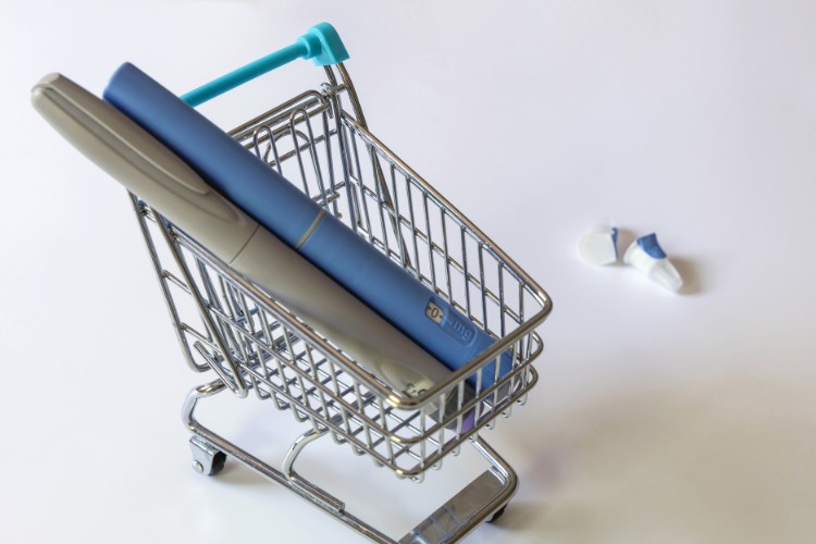 Ozempic-Valor Duas canetas de Ozempic, uma azul e uma cinza) dentro de pequeno carrinho que imita os de supermercado