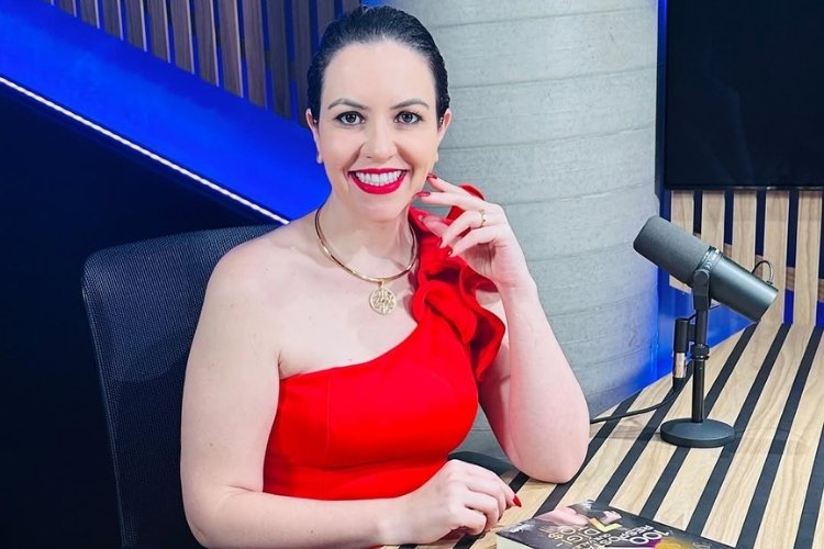 Aline-Kummer Foto de Aline Kummer usando blusa vermelha de um ombro só em podcast sobre como transformar seus sonhos em metas diárias