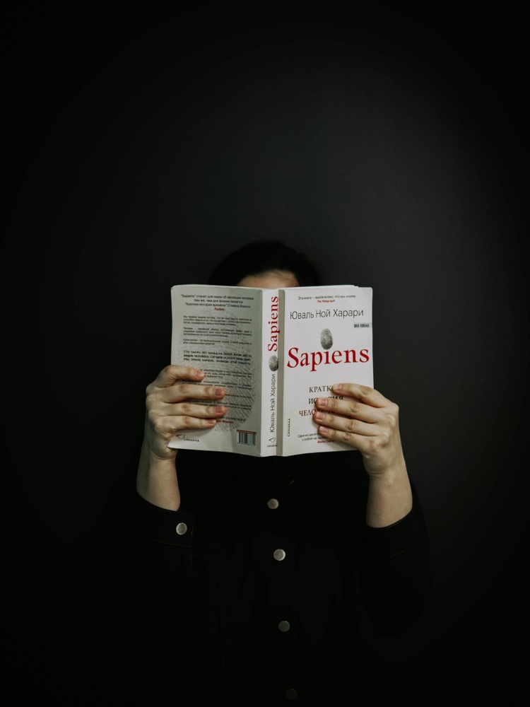 Elitismo-Cultural-2 Pessoa de pele clara com roupa preta lendo livro "Sapiens"