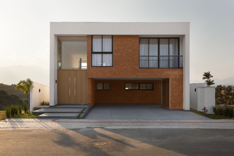 Casa-435-M2-1 Faixada de mansão em bege com muitas janelas em vidro e garagem ampla