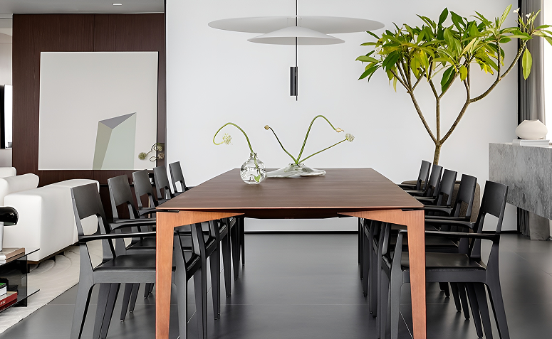 jasmim-manga cultivado em vaso grande decorando sala de jantar minimalista, com tronco escultural e folhas verdes em ambiente iluminado.