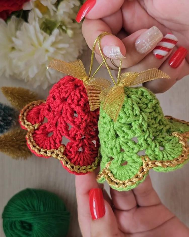 Croche-De-Natal-Facil-De-Fazer-6 Mãos com unhas natalinas segurando Sinos de Natal de crochê vermelho e verde com detalhes dourados