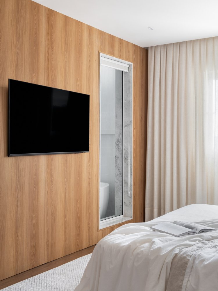 Apartamento-Decorado-De-170M2-12 Suíte com parede de madeira com TV e porta de vidro para o banheiro