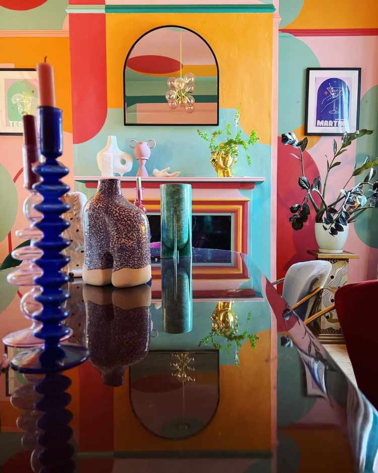 Decorar-Com-As-Cores-Da-Bandeira-Lgbtqia-3 Sala com parede colorida, mesa preta, plantas e itens decorativos coloridos