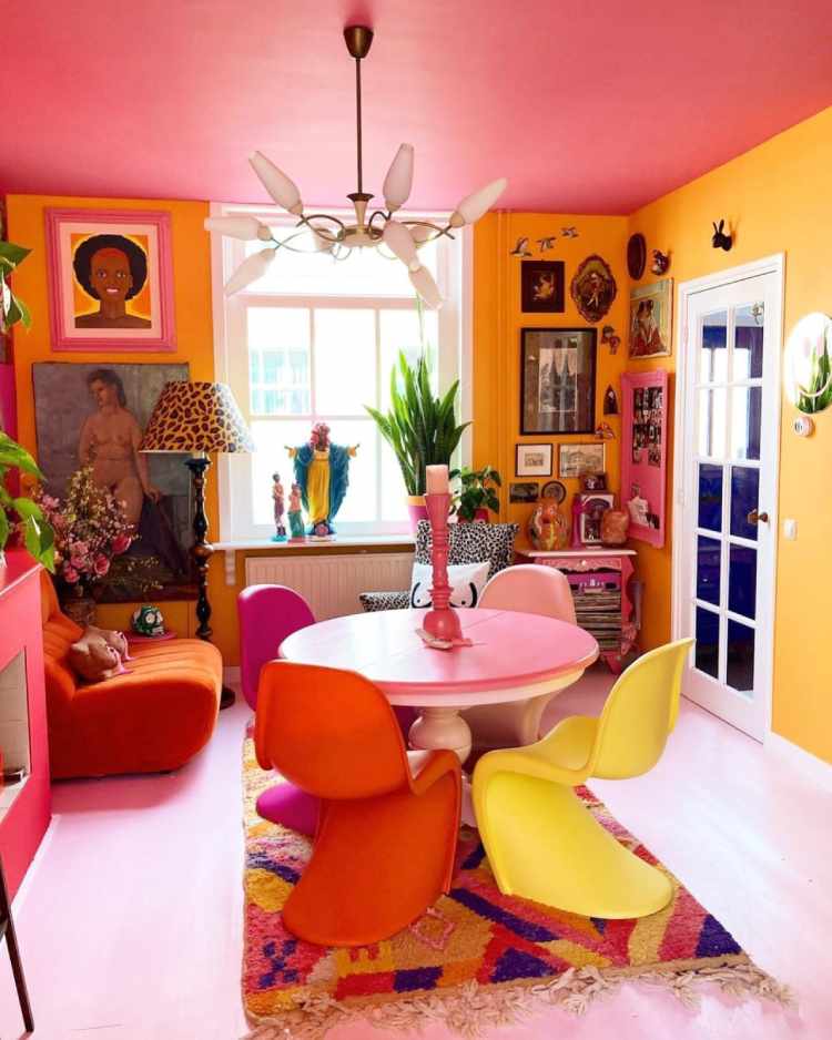 Decorar-Com-As-Cores-Da-Bandeira-Lgbtqia-5 Sala com teto rosa, paredes laranjas, quadros coloridos, mesa rosa, poltrona de onça, cadeiras em tons de rosa, laranja e amarelo, poltrona laranja, tapete colorido e mais