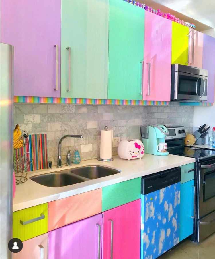 Decorar-Com-As-Cores-Da-Bandeira-Lgbtqia Cozinha com armários envelopados em rosa, roxo, verde, azul e amarelo, torradeira da Hello Kitty, tábua colotida e mais